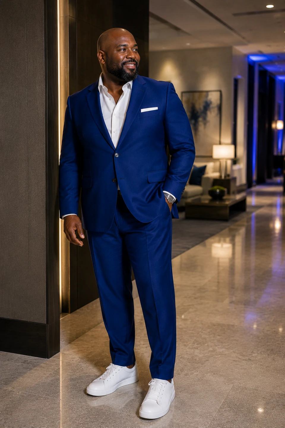 Black man in a contemporary blue suit with a crisp white shirt and clean white sneakers.